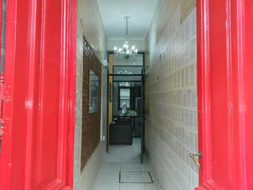 a hallway with a red door and a hallway with a hallway at Kin Hotel in Zárate