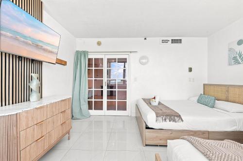a bedroom with a bed and a flat screen tv at Girasole Rentals Suites in Miami Beach