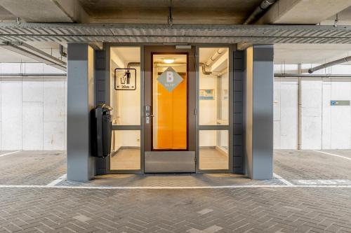 an orange door in a building with a sign on it at BizStay Harbour I Scheveningen Apartments in Scheveningen