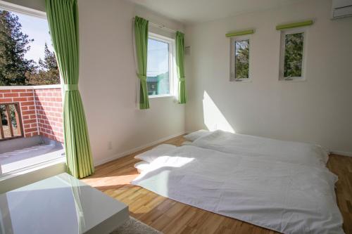 a bedroom with a white bed and a window at Yushin in Fujikawaguchiko
