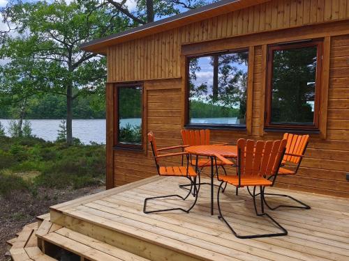 a wooden deck with a table and chairs on a cabin at Långasjönäs Camping & Stugby in Karlshamn