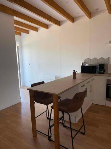 a kitchen with a wooden table and two chairs at Maison de Campagne 