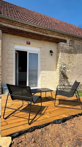two chairs and a table on a wooden deck at Maison de Campagne 