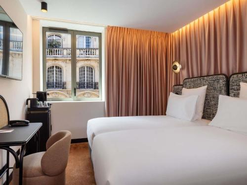 a hotel room with a bed and a window at Hotel Maison Hamelin Paris - Handwritten Collection in Paris