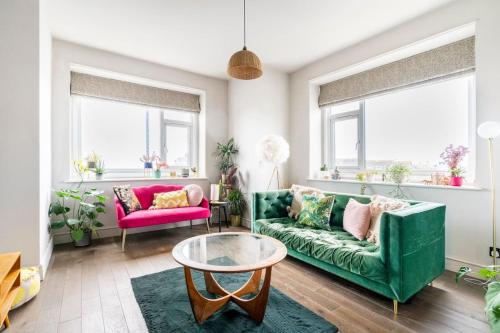 a living room with a green couch and a table at Walpole Bay Sea Views in Margate