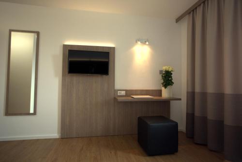 a hotel room with a flat screen tv on the wall at Airport Hotel Walldorf in Mörfelden-Walldorf