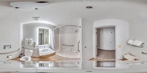 a bathroom with two mirrors and a sink at Comfort Inn Mount Vernon Downtown in Mount Vernon
