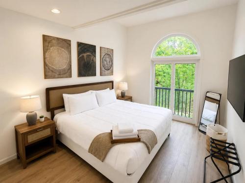 a bedroom with a large white bed and a window at The Accessible Atom | Historic Main in St. Charles