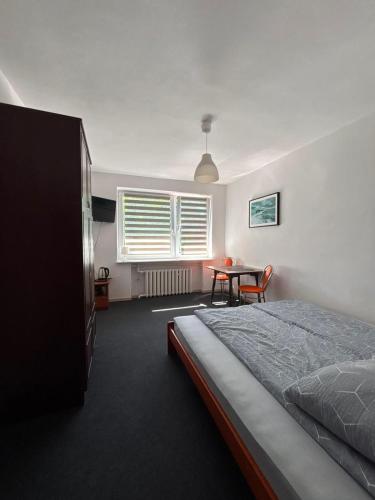 a bedroom with a bed and a table and a window at Ośrodek Wczasowy Daga in Dziwnów