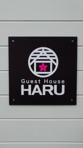 a sign for a guest house haru on a wall at Hiroshima Guesthouse HARU in Hiroshima