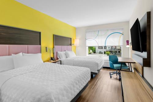 a hotel room with two beds and a desk and a tv at Tru By Hilton Princeton in Princeton