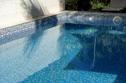 a swimming pool with blue tiles on the side of a building at Cabañas Alpinas en Oxapampa in Oxapampa