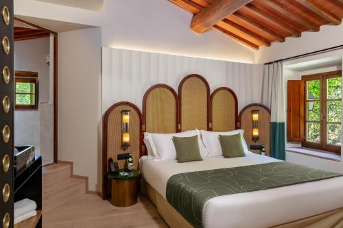 a bedroom with a large bed in a room at Chapter Chianti, a Member of Design Hotels in Cavriglia