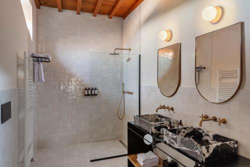 a bathroom with two sinks and a shower at Chapter Chianti, a Member of Design Hotels in Cavriglia