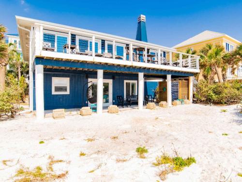 a blue house with a deck on the beach at Blue Heron in Pensacola Beach