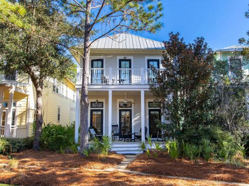 a white house with a porch and a balcony at Watercolor Whimsea in Seagrove Beach