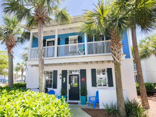a blue and white house with palm trees at Bungalows at Seagrove #142 in Seagrove Beach