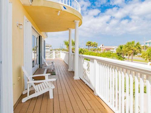 a balcony with two chairs and a view of the ocean at Sunglow Bungalow in Pensacola Beach