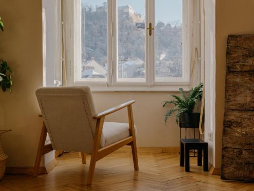 a chair sitting in a room with a window at City Center Boutique Apartments - Schlossberg View - Free Parking in Graz