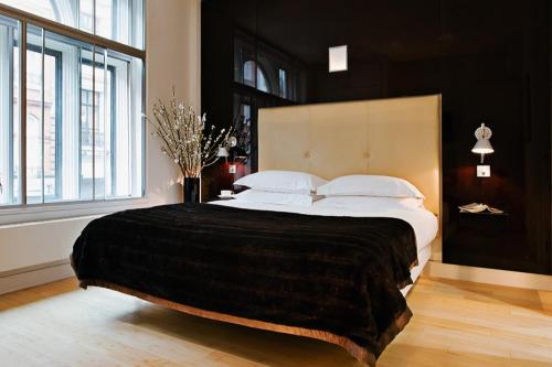 a bedroom with a large bed with a large window at No.5 Maddox Street in London