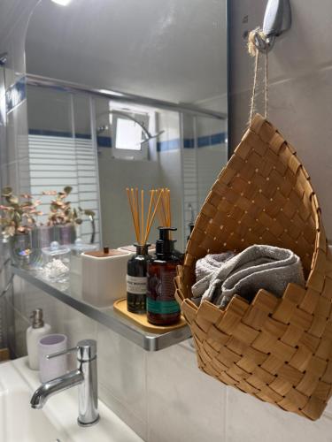 a bathroom sink with a basket on the counter at Blooming 31 AXD in Alexandroupoli