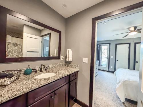 a bathroom with a sink and a mirror and a bed at New Luxury Lakefront Walk to Wisp in McHenry