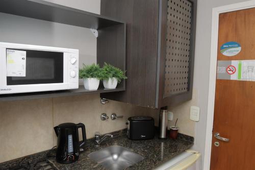 a kitchen with a sink and a microwave at Rosario Temporal in Rosario