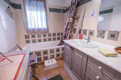 a bathroom with a sink and a tub at La villa d'alyxia in La Bastide-Puylaurent