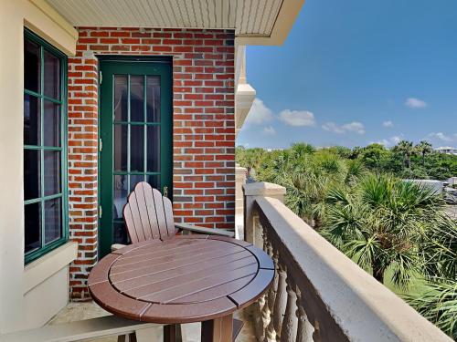 a wooden chair sitting on a balcony with a table at Village Of South Walton #263A in Rosemary Beach