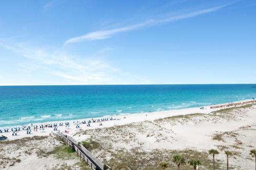 a group of people walking on the beach at Emerald Isle #602 in Pensacola Beach