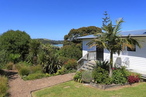 a house with a palm tree in a garden at Waiheke Island Motel in Ostend