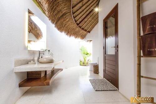a bathroom with a sink and a mirror at Villa Kaaiti in Uluwatu