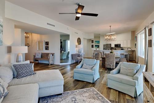 a living room with a couch and chairs and a kitchen at Crystal View #303 in Destin