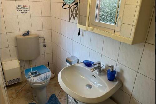 a bathroom with a sink and a toilet at Ferienwohnung 2 Gemutlich & komfortabel im Erdgeschoss in Borkum