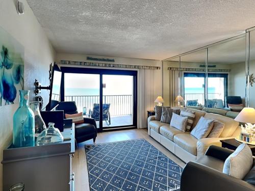 a living room with a couch and a view of the ocean at Ocean Breeze East #303 in Perdido Key