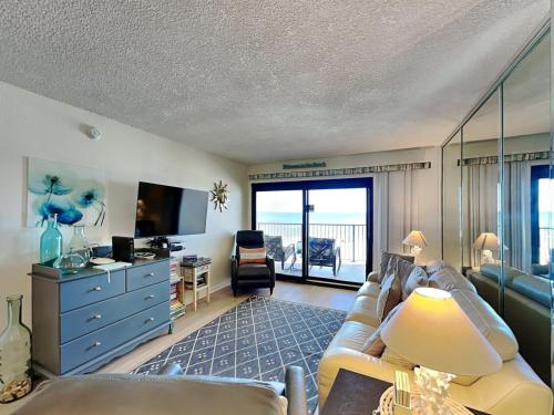 a living room with a couch and a television at Ocean Breeze East #303 in Perdido Key