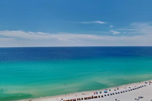 a beach with a group of people and the ocean at Beach Club #1804C in Pensacola Beach
