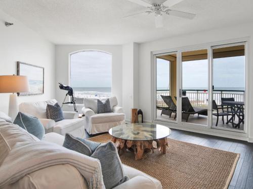 a living room with white furniture and a view of the ocean at Beach Colony Towers #2B - Villa Monarch in Perdido Key