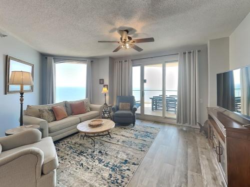 a living room with a couch and a tv at Beach Colony West #PH3B 18B in Perdido Key