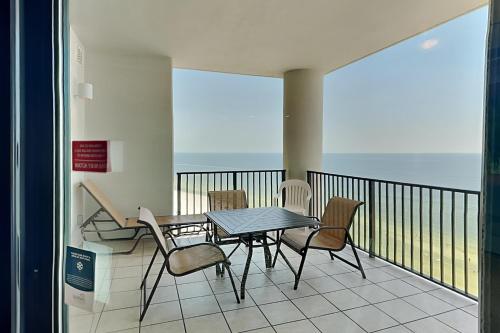 a balcony with a table and chairs and the ocean at Phoenix West II #1407 in Orange Beach