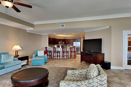 a living room with a couch and a tv at Phoenix West II #1407 in Orange Beach