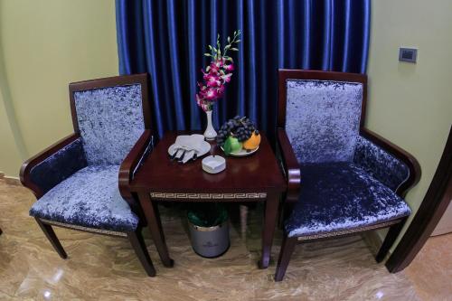 two chairs and a table with a vase of flowers at Gallant Hotel 168 in Hai Phong