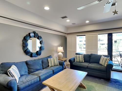 a living room with a blue couch and a table at Aegean 327 in Destin