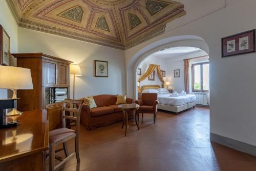 a living room with a couch and a bed in a room at Relais Cloister Pienza in Pienza