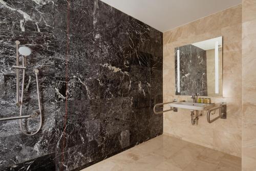 a bathroom with a shower and a sink at Hilton Astana in Astana