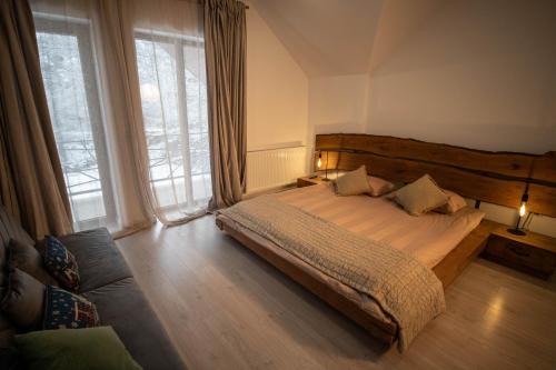 a bedroom with a bed and a couch and windows at La Stanca in Cheia
