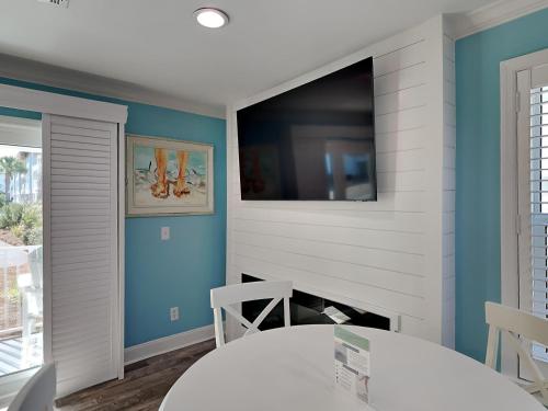 a dining room with a table and a tv on the wall at Beachside Villas 911 in Seagrove Beach