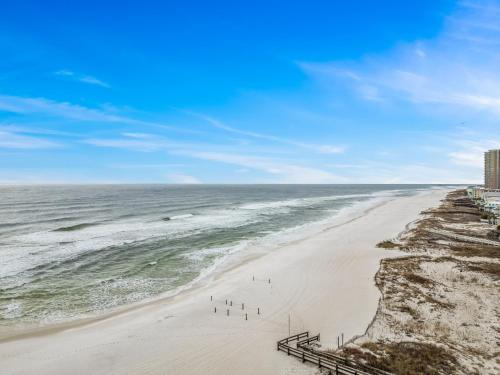 a beach with a group of people standing on the sand at The Oasis at Orange Beach 1707 in Orange Beach