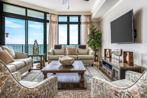 a living room with couches and a tv at The Oasis at Orange Beach 1707 in Orange Beach