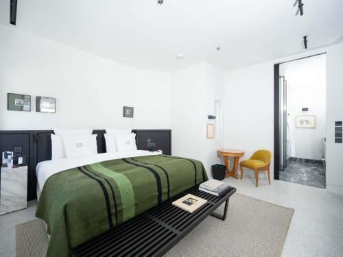 a bedroom with a large bed and a table at Athens Capital Suites-MGallery Collection in Athens